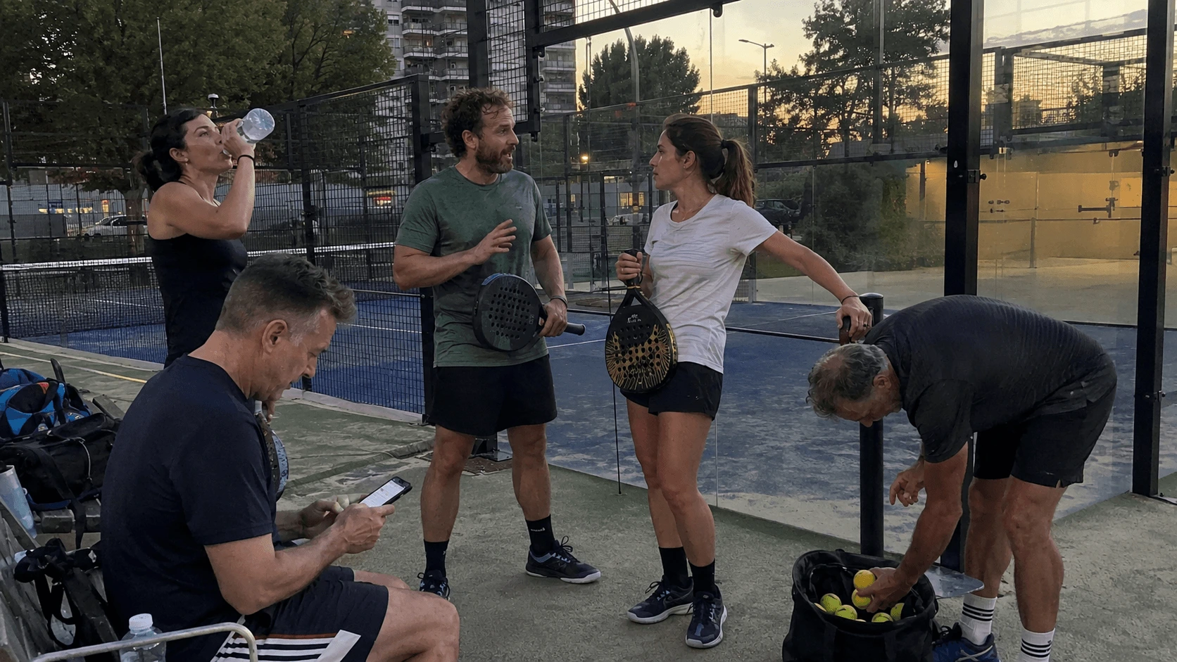 Padel club members talking after an evening session