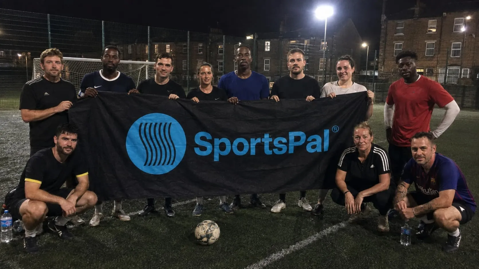 Football participants holding the SportsPal banner after a match