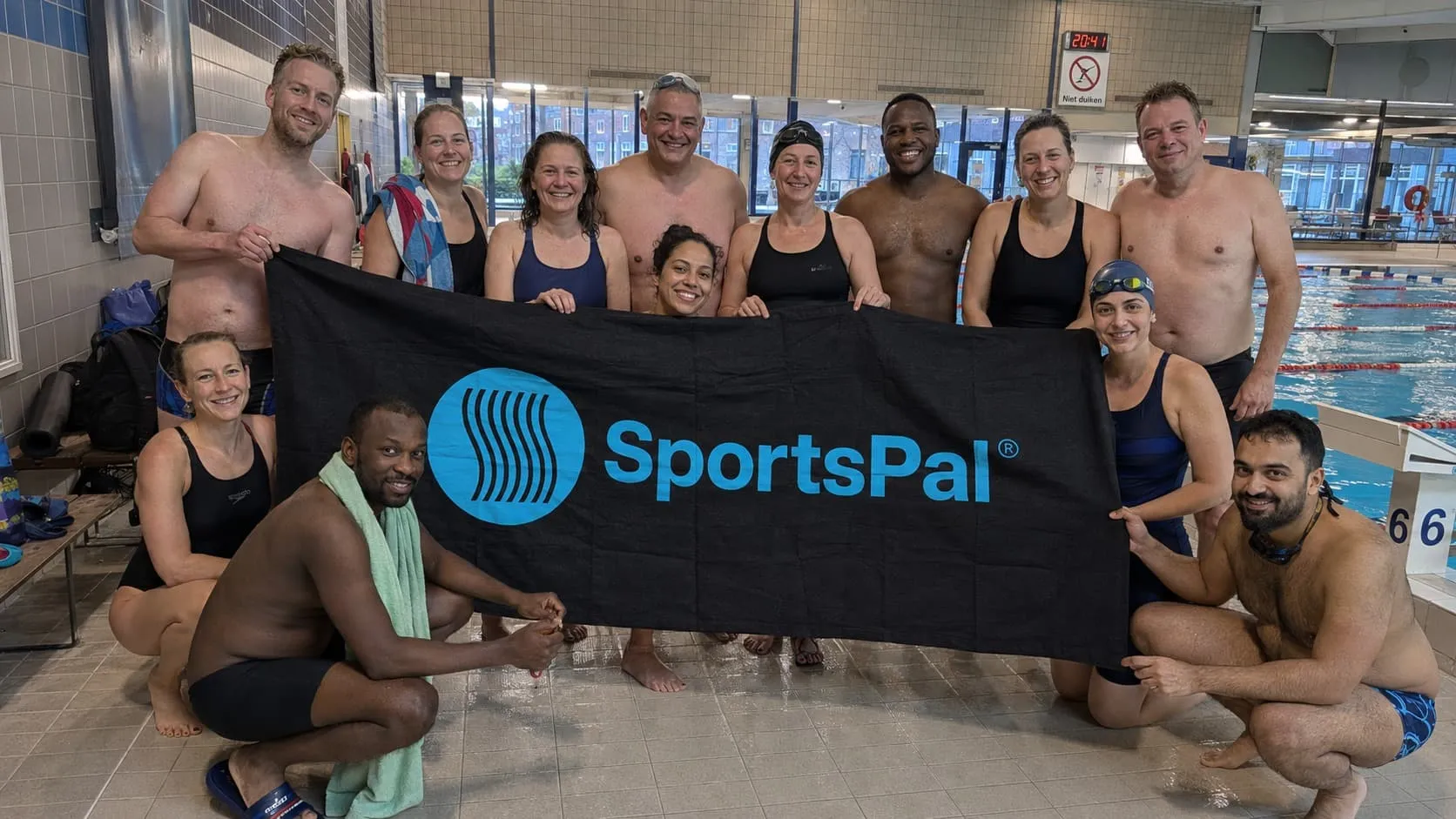 Swimming participants gathered with the SportsPal banner