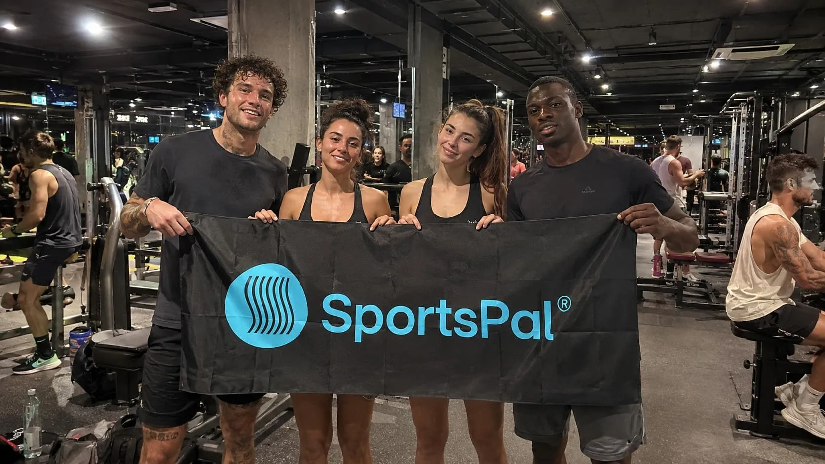 Gym participants holding the SportsPal banner after training