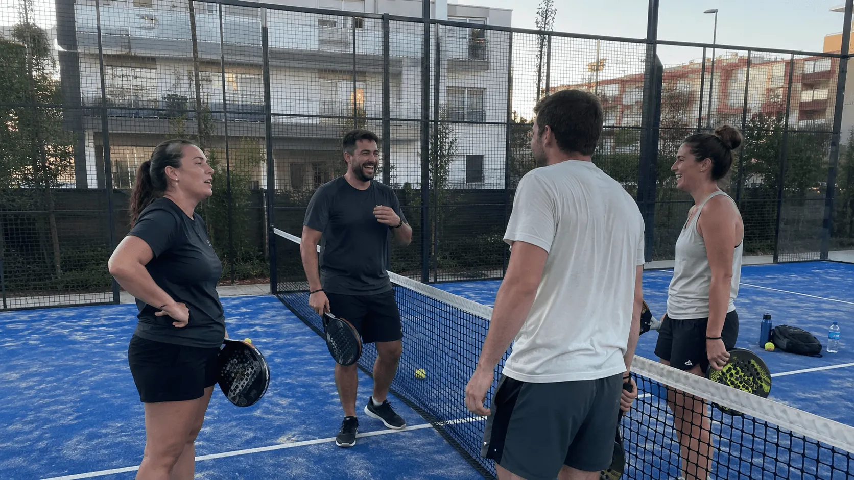 Four people talking after a casual padel session