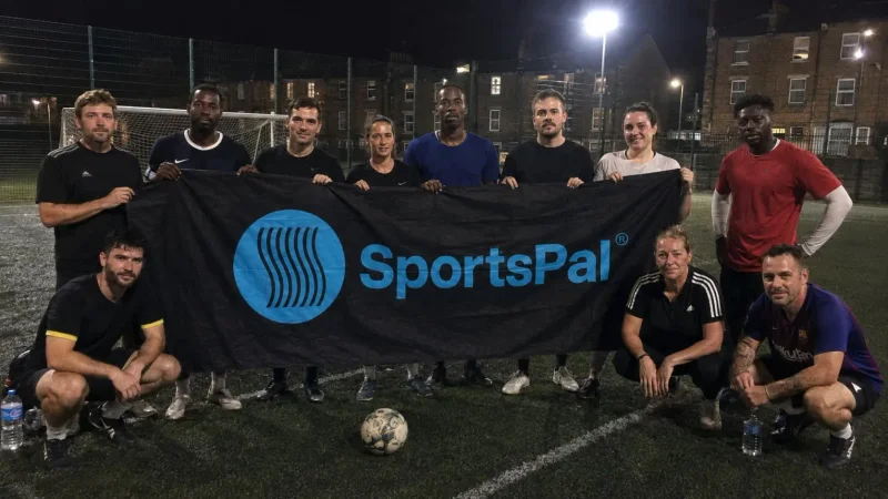 Football participants holding the SportsPal banner after a match