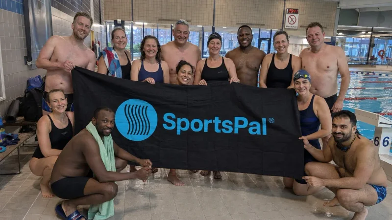 Swimming participants gathered with the SportsPal banner